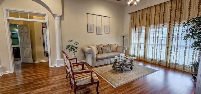 sitting room with decorative columns, dark hardwood / wood-style floors, and ceiling fan