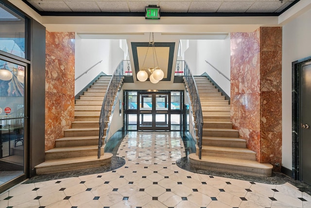 staircase featuring a high ceiling and a drop ceiling