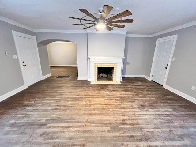 unfurnished living room with a tiled fireplace, hardwood / wood-style flooring, ornamental molding, and ceiling fan