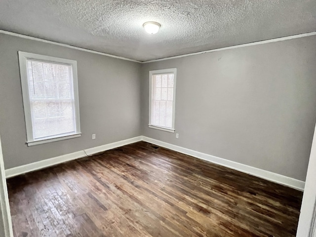 spare room with ornamental molding, dark wood-type flooring, and a textured ceiling