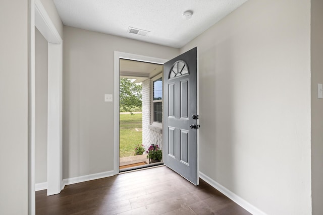 foyer with dark hardwood / wood-style floors and a textured ceiling