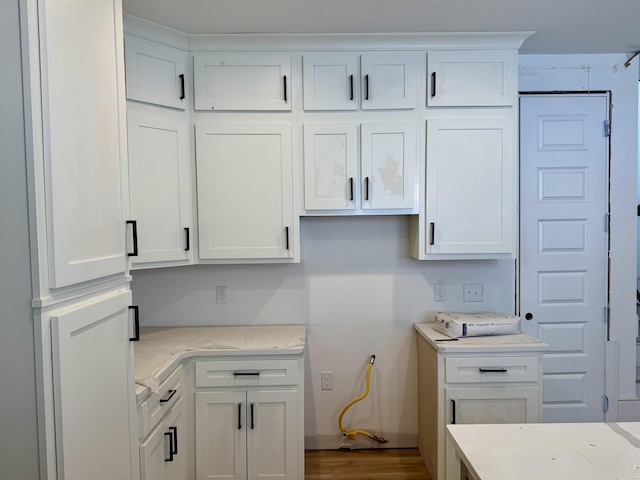 5545 Shipp Rd, Millington, TN 38053 - kitchen with white cabinetry, wood finished floors, and light stone countertops