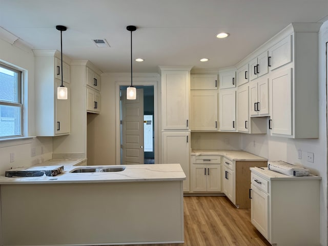 5545 Shipp Rd, Millington, TN 38053 - kitchen with light wood-style floors, a peninsula, light stone counters, recessed lighting, and decorative light fixtures