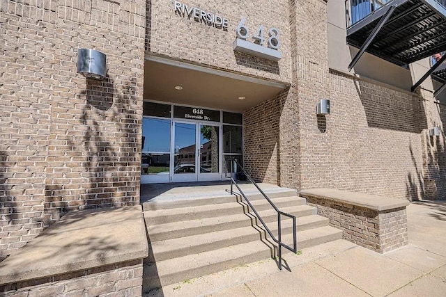 view of exterior entry featuring brick siding