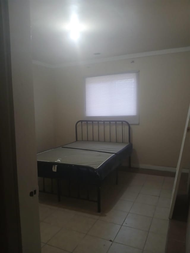 bedroom featuring ornamental molding and light tile patterned floors