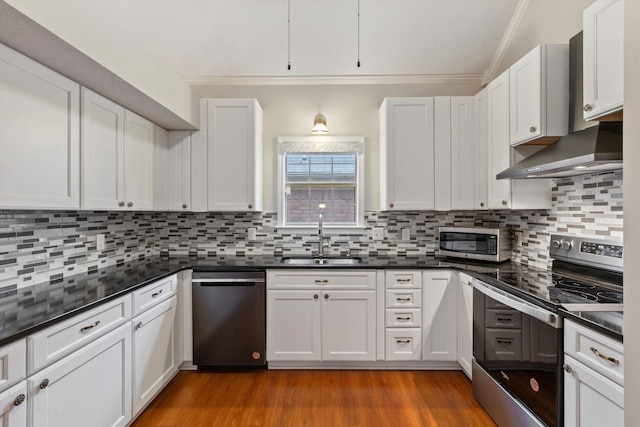 kitchen featuring white cabinetry, appliances with stainless steel finishes, sink, and wall chimney range hood