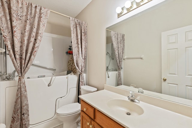 bathroom with vanity, a textured ceiling, and toilet