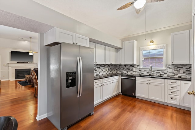 kitchen with dishwashing machine, stainless steel fridge with ice dispenser, pendant lighting, and sink