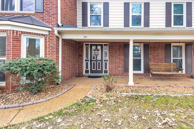 view of exterior entry featuring covered porch