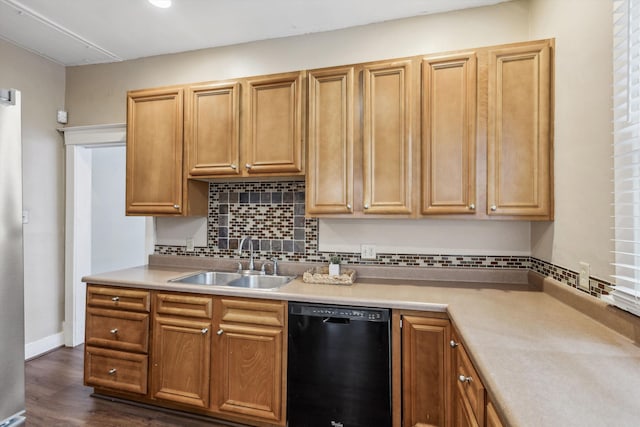 kitchen featuring sink, backsplash, dark wood-type flooring, and black dishwasher