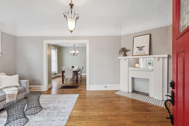 living room with hardwood / wood-style floors, crown molding, and a chandelier