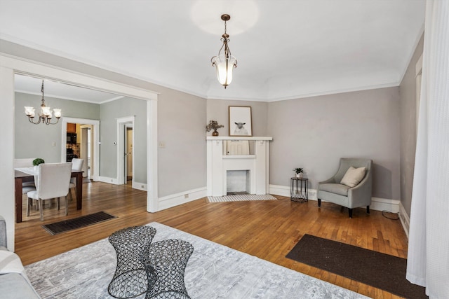 living room featuring hardwood / wood-style flooring, crown molding, and a notable chandelier