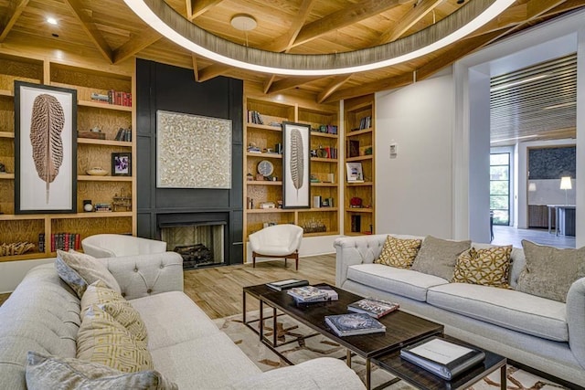 living room featuring built in shelves, wood ceiling, beamed ceiling, a fireplace, and hardwood / wood-style floors