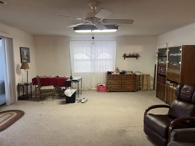 sitting room featuring crown molding, light colored carpet, ceiling fan, and a wealth of natural light