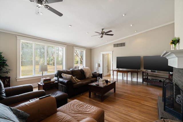 living room featuring lofted ceiling, wood-type flooring, ornamental molding, and ceiling fan