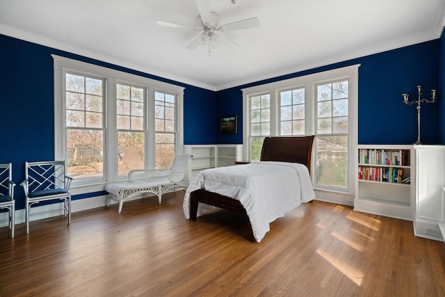 bedroom featuring hardwood / wood-style floors, crown molding, and ceiling fan