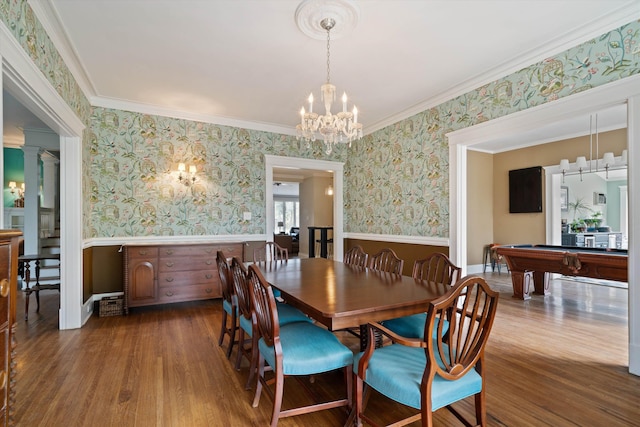 dining area featuring decorative columns, wood-type flooring, ornamental molding, and a chandelier