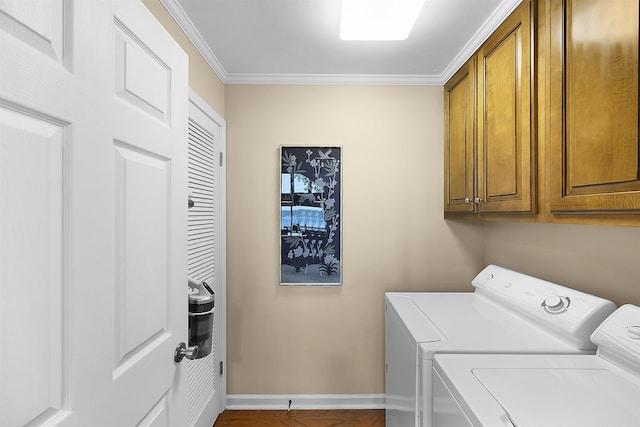 washroom with cabinets, washing machine and dryer, and crown molding