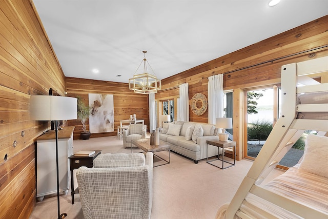 carpeted living room featuring a notable chandelier and wooden walls