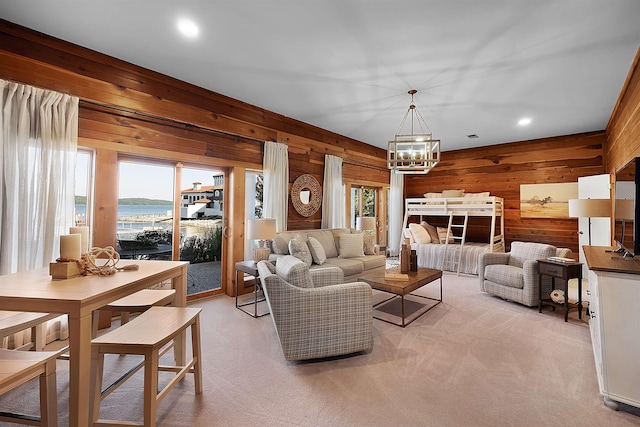 carpeted living room with an inviting chandelier and wooden walls