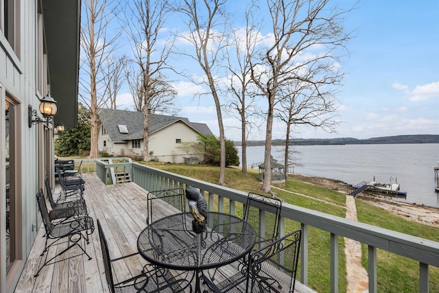 wooden deck with a water view and a yard