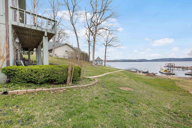 view of yard with a water view and a dock