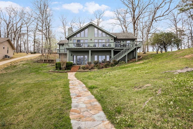 back of property featuring a deck and a lawn