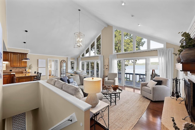 living room with dark hardwood / wood-style flooring, beam ceiling, high vaulted ceiling, and an inviting chandelier