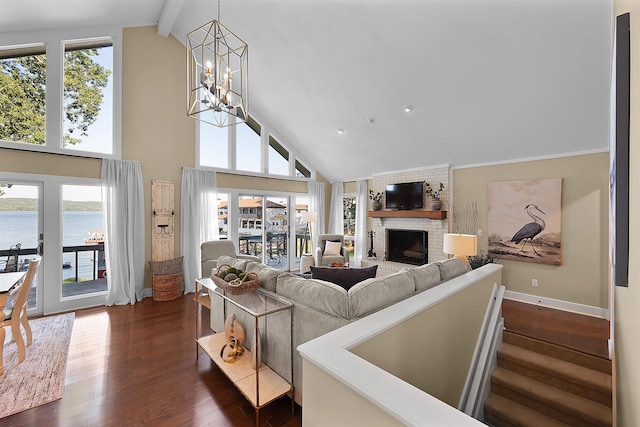 living room featuring a fireplace, beamed ceiling, a chandelier, a water view, and dark wood-type flooring