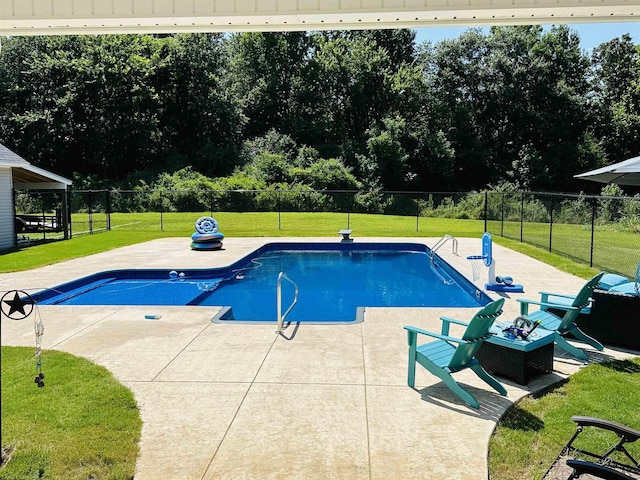 view of swimming pool featuring a patio area and a lawn