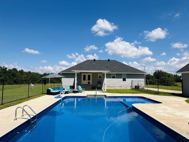 view of pool with a patio, outdoor lounge area, central AC, and a lawn