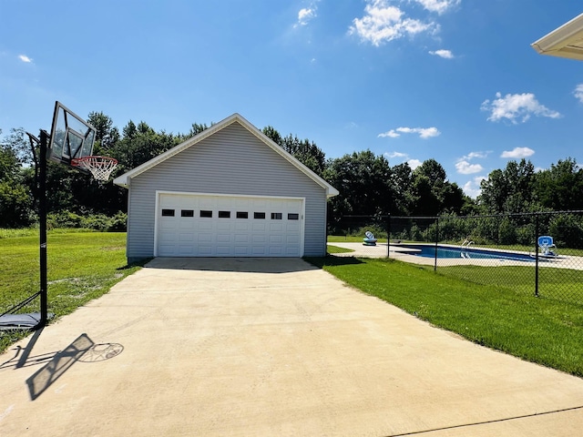 garage with a yard and a fenced in pool