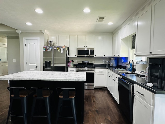 kitchen with sink, a center island, white cabinets, and appliances with stainless steel finishes