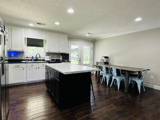 kitchen with white cabinetry, dark hardwood / wood-style floors, sink, and a kitchen island