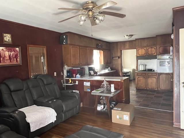 living room with dark wood-type flooring and ceiling fan