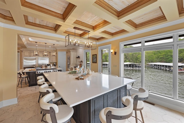 kitchen featuring a water view, a kitchen island, plenty of natural light, and pendant lighting