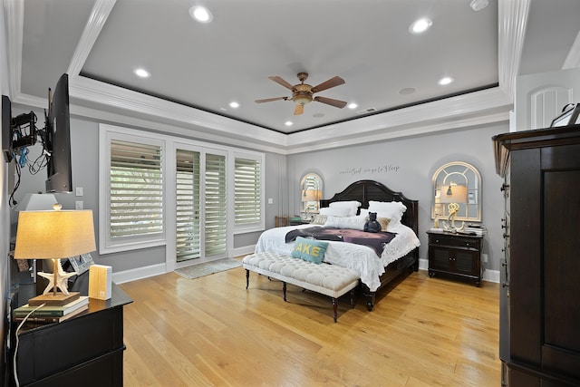 bedroom featuring light hardwood / wood-style flooring, ceiling fan, access to exterior, ornamental molding, and a raised ceiling