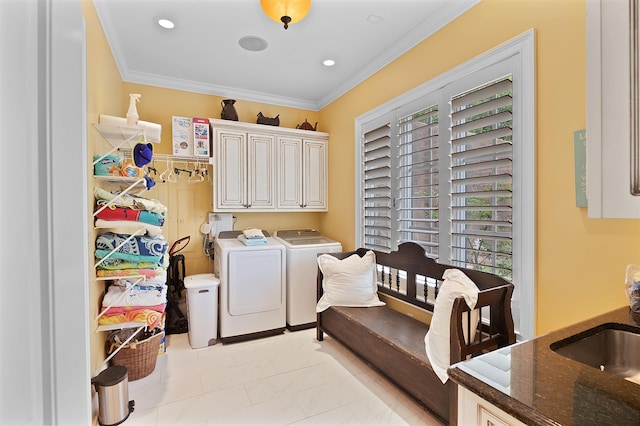 laundry room featuring cabinets, ornamental molding, sink, and washing machine and clothes dryer