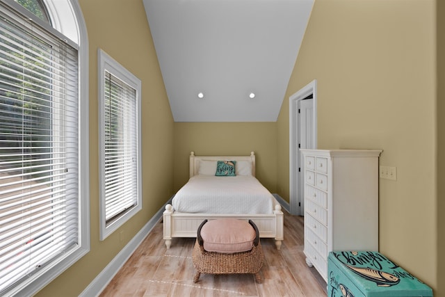 bedroom with vaulted ceiling and light hardwood / wood-style floors