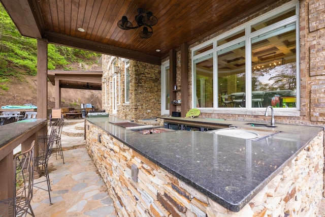 view of patio featuring an outdoor bar and ceiling fan