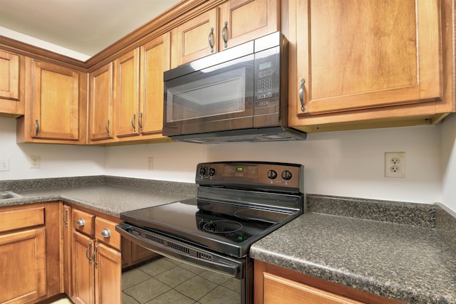 kitchen with tile patterned flooring and black electric range