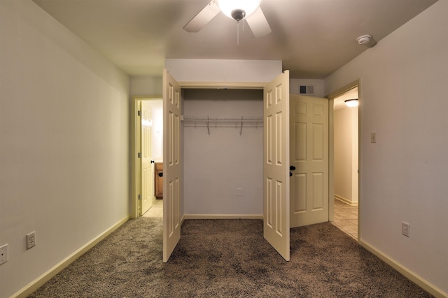 unfurnished bedroom featuring a closet, ceiling fan, and dark colored carpet