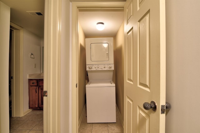 washroom featuring stacked washer / dryer and light tile patterned floors