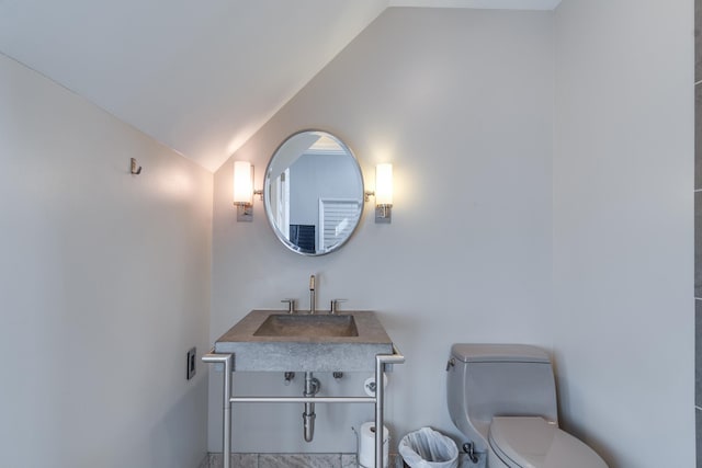 bathroom with vanity, lofted ceiling, and toilet