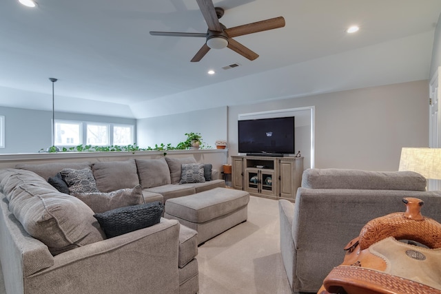 carpeted living room with ceiling fan and lofted ceiling