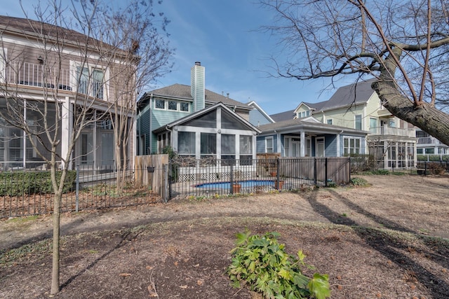 back of house featuring a fenced in pool and a sunroom