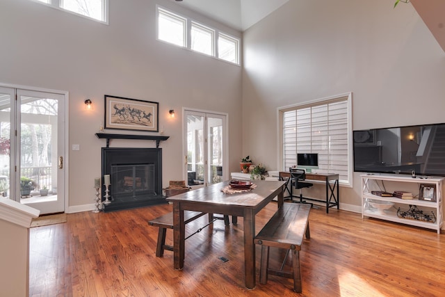 dining room featuring hardwood / wood-style floors and a high ceiling