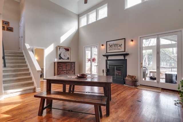 dining space with wood-type flooring and a high ceiling