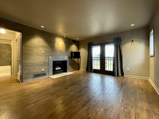 unfurnished living room with wood-type flooring and french doors