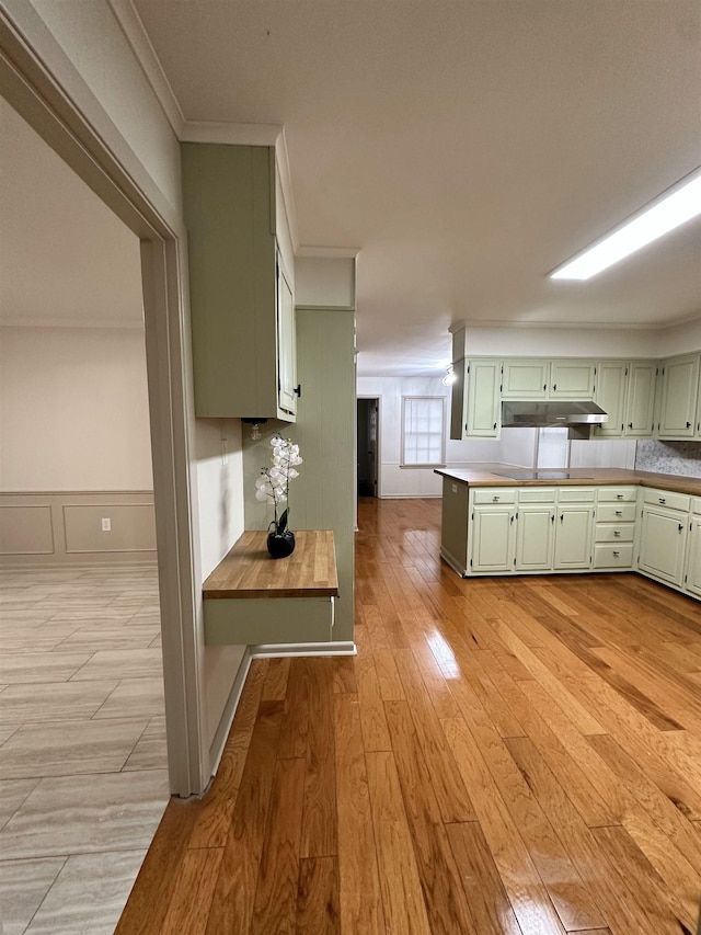 kitchen with ornamental molding, light hardwood / wood-style floors, and green cabinets